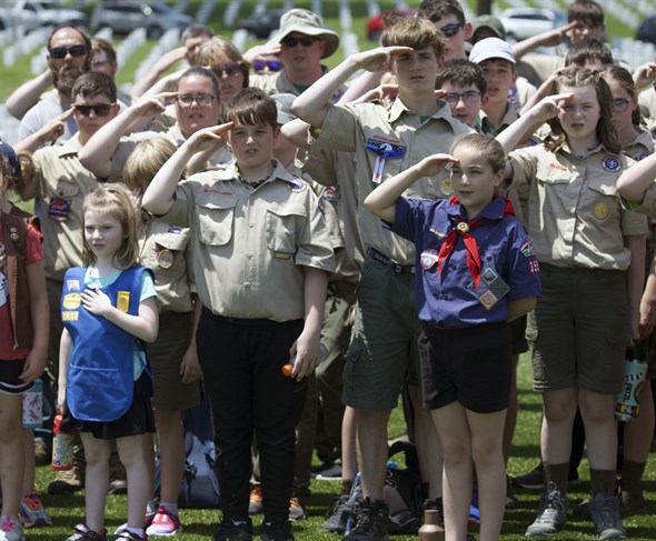 Scouts standing at attention and saluting during a ceremony